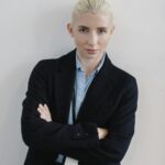 Professional businesswoman standing confidently with arms crossed in an office setting.